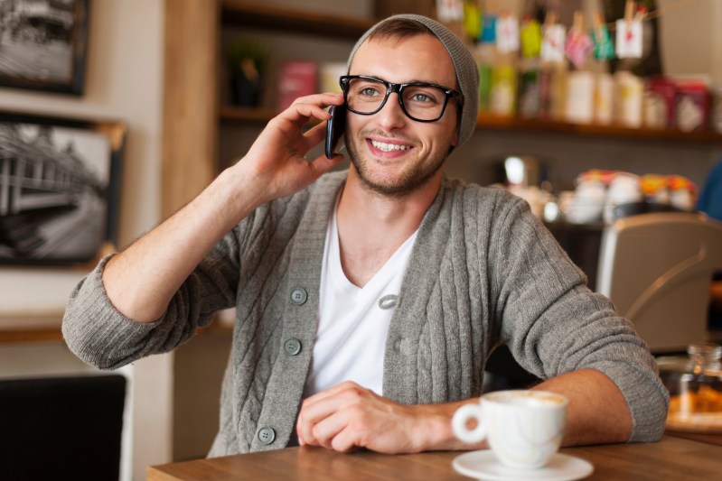 hipster man talking by mobile phone at cafe